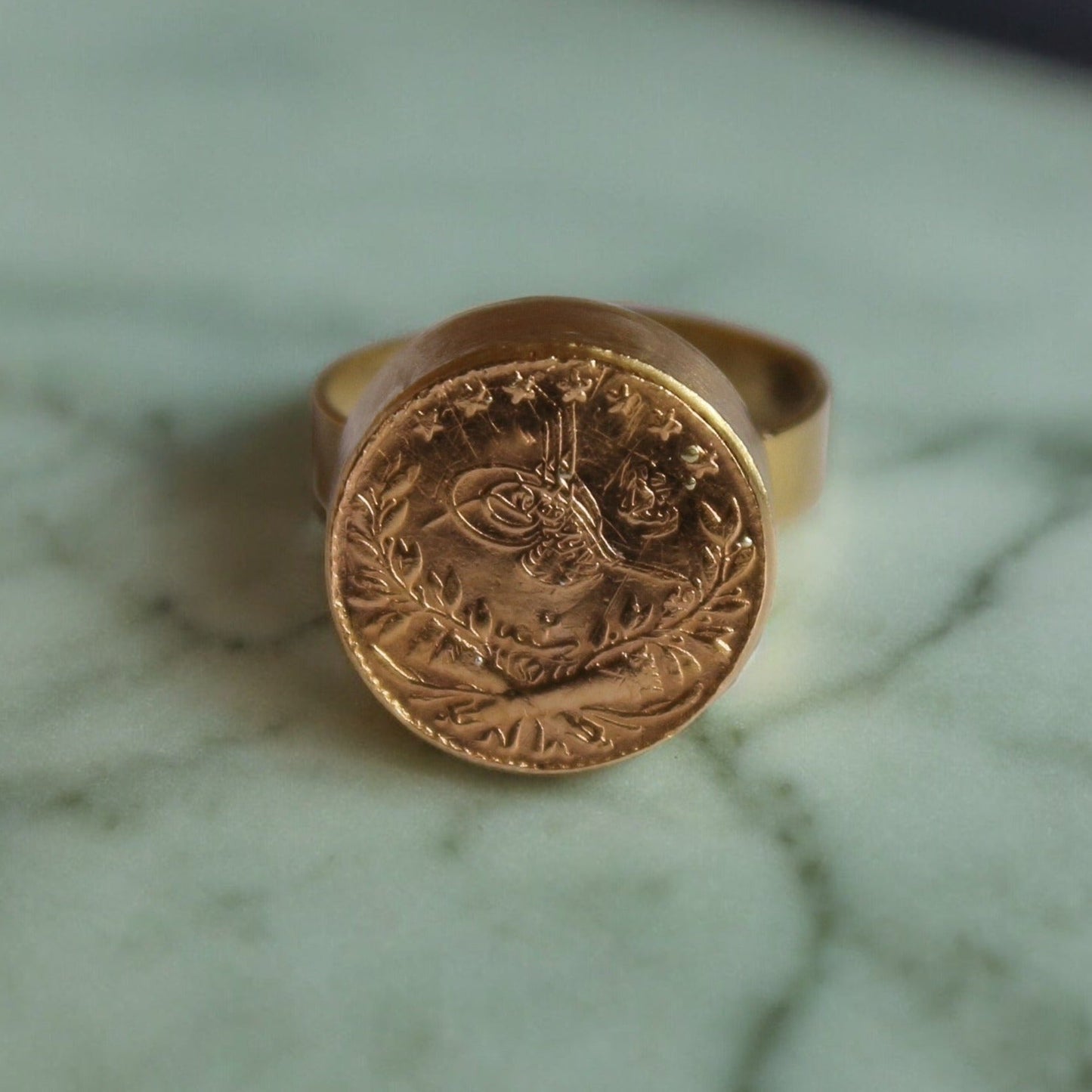 18k Gold Ring with Ottoman Stamp calligraphy. Islamic jewelry. Gold Adjustable Ring on a green background