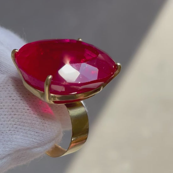 A short video Clip of an 18k Yellow Gold Rubellite Ring, Large Oval Rubellite and wide band held by a hand in a white glove
