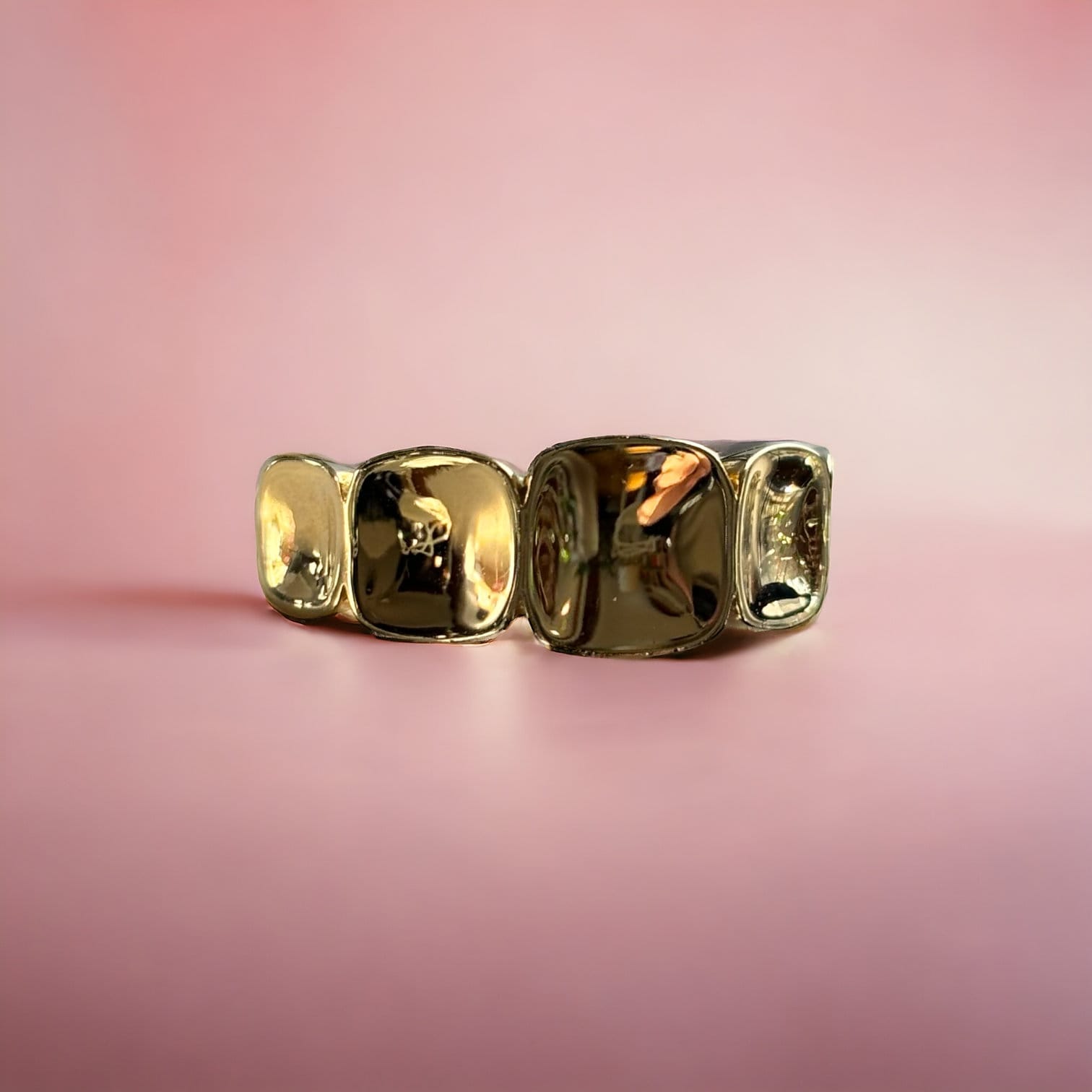 18k Incrementally Sized Rounded Edged Squares Gold Ring Facing Straight on a pink background